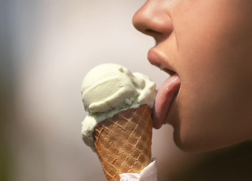 A person licking an ice cream cone.