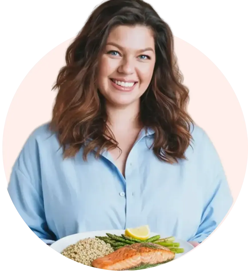Smiling woman in front of a nutritious meal of salmon and brown rice, representing balanced living and healthy weight-loss support.