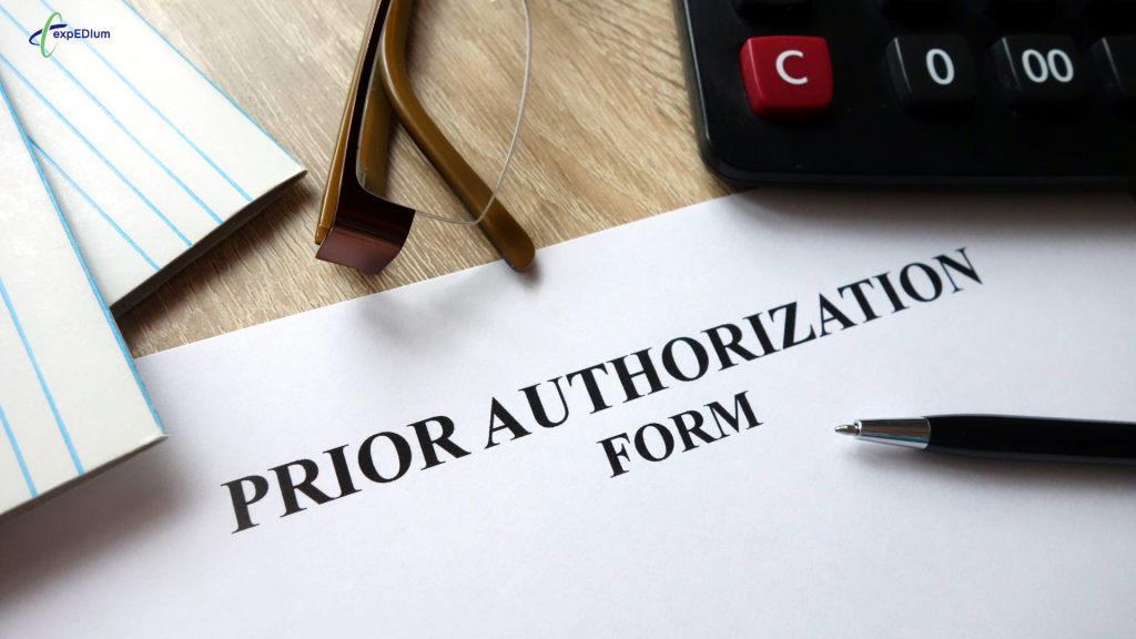 Prior authorization form document on a desk with reading glasses, a pen, a notepad, and a calculator.